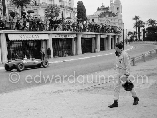 Jim Clark walking back to the pits (broken clutch). Bruce McLaren, winner of the race passig. Monaco Grand Prix 1962. Monaco Grand Prix 1962. - Photo by Edward Quinn