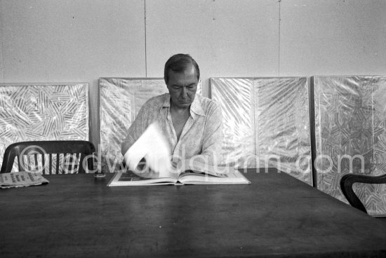 Jasper Johns at his Studio, viewing the Max Ernst book by Edward Quinn. New York 1982. - Photo by Edward Quinn