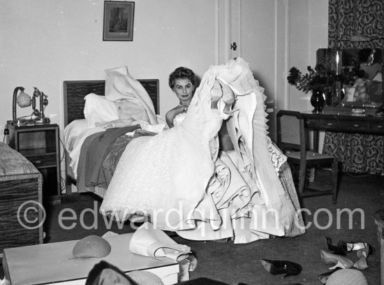 Sophia Loren in her Carlton Hotel room during the Cannes Film Festival wearing an evening gown designed by Emilio Schuberth, 27 April 1955. - Photo by Edward Quinn