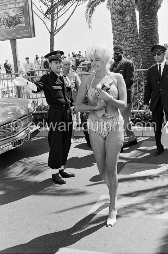 An observant policeman. Curvy Jane Mansfield and her hardly recognizable Chihuahua. Cannes 1958. Car: Opel Kapitän 1956 or 1957. - Photo by Edward Quinn