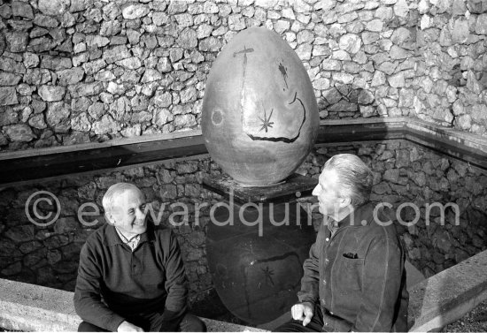 Joan Miró and Aimé Maeght in the gardens of Musée Maeght in front of a small pool with an "Oeuf cosmique" by Miró in center. Saint-Paul-de-Vence 1964. - Photo by Edward Quinn