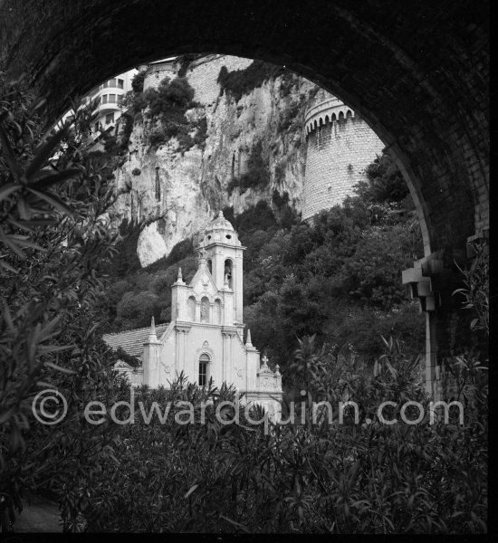 Chapel Sainte Dévote, Monaco. It is behind the first turn of the Circuit of Monaco Grand Prix, a tight right-hander, that got his name from it. The chapel is usually obscured by crash barriers and corporate signage on race weekends, so you will probably never catch a glimpse of it on TV. Monaco 1950 - Photo by Edward Quinn