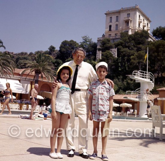 Aristotle Onassis and his children Alexander and Christina. Monte Carlo Beach with Villa La Vigie 1957.  Roquebrune-Cap-Martin, 
Construite en 1902 pour Sir William Ingram de l\'Illustrated London News, aristocrate, homme d\'affaires et homme politique britannique, la villa La Vigie a ensuite été rachetée par la SBM de Monte-Carlo, pionnière de l\'industrie hôtelière à Monaco et sur la Côte d\'Azur. La Vigie était dans les années 1990 la maison du célèbre designer Karl Lagerfeld, où il a créé des collections de luxe pour la maison Chanel.) - Photo by Edward Quinn