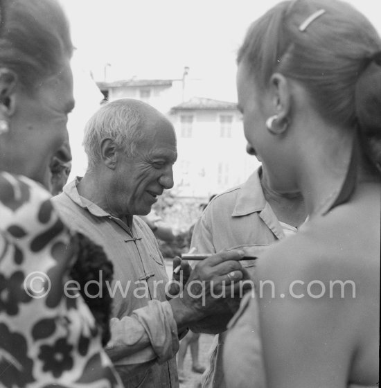 Pablo Picasso signing autographs on the occasion of the summer ceramics exhibition "Japon. Céramique contemporaine" at the Nérolium. Vallauris 21.7.1951. - Photo by Edward Quinn
