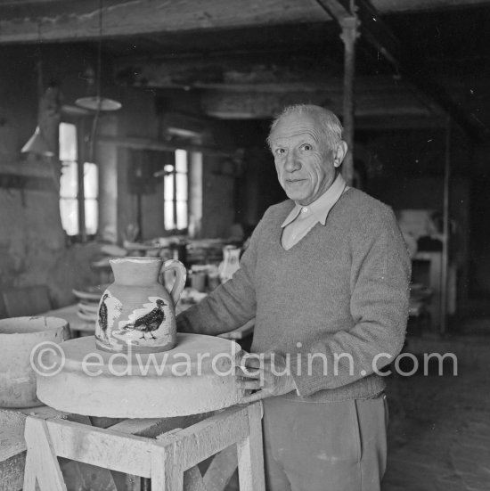 Pablo Picasso using a potter\'s wheel to examine a finished ceramic jug at the Madoura pottery Vallauris. 23.3.1953. - Photo by Edward Quinn