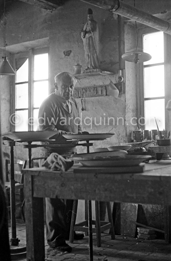 Pablo Picasso at work at the Madoura pottery in Vallauris. Above him is a statue of St-Claude, the patron saint of the potters, whose name was given to his younger son. Vallauris 23.3.1953. - Photo by Edward Quinn