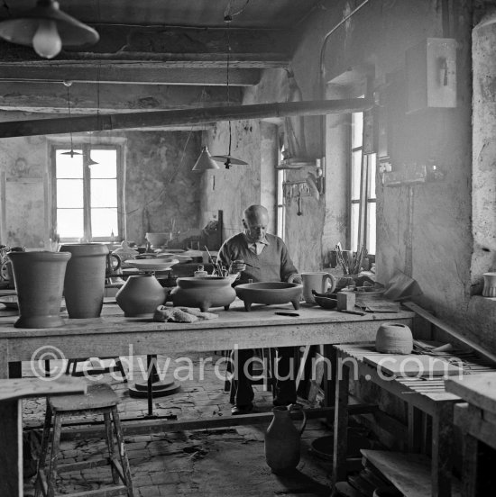 Pablo Picasso at work at the Madoura pottery in Vallauris. Above him is a statue of St-Claude, the patron saint of the potters, whose name was given to his younger son. Vallauris 23.3.1953. - Photo by Edward Quinn