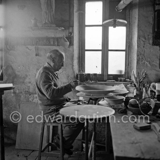 Pablo Picasso at work at the Madoura pottery in Vallauris. Above him is a statue of St-Claude, the patron saint of the potters, whose name was given to his younger son. Vallauris 23.3.1953. - Photo by Edward Quinn