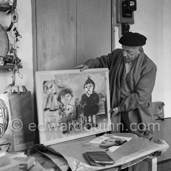 Pablo Picasso, preparing for an exhibition of his latest works, holds up a picture of Claude Picasso and Paloma Picasso. Vallauris 1953. - Photo by Edward Quinn