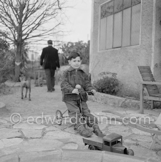 Paulo Picasso, Claude Picasso and boxer dog Jan in the garden of La Galloise. With tricycle. Vallauris 1953. - Photo by Edward Quinn