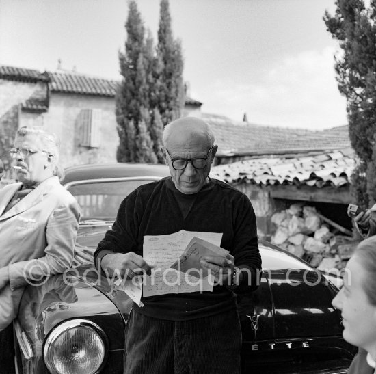 Outside Madoura pottery, Pablo Picasso reading a letter. On the right Irène Rignault. Vallauris 1953. Car: Ford Vedette 1953 - Photo by Edward Quinn