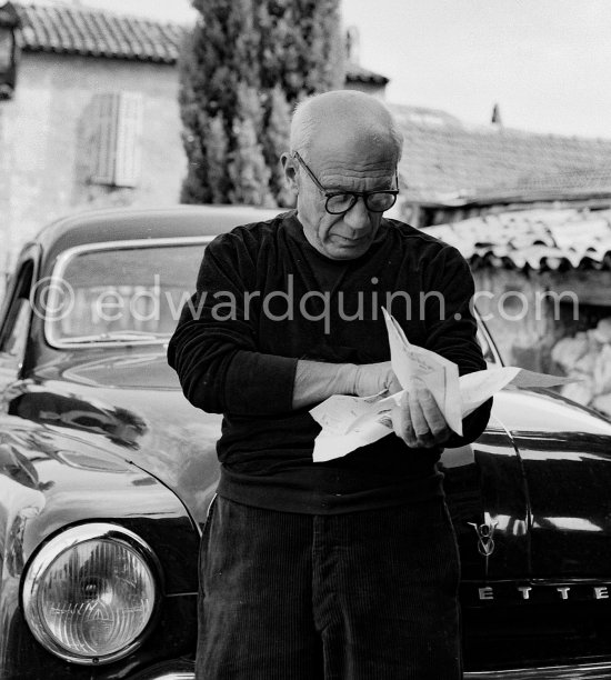 Outside Madoura pottery, Pablo Picasso reading a letter. On the right Irène Rignault. Vallauris 1953. Car: Ford Vedette 1953 - Photo by Edward Quinn