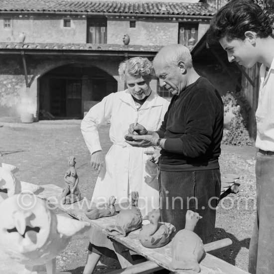 Pablo Picasso with some of the ceramic figures he made in clay, before they are put in the kiln. With him is Suzanne Ramié of the Madoura pottery. Suzanne is wearing a pendant by Pablo Picasso. Outside Madoura pottery, Vallauris 1953. - Photo by Edward Quinn