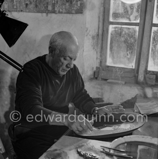 Pablo Picasso working on first version of plate of a woman (Irène Rignault, Madame X), during filming of "Pablo Picasso", directed by Luciano Emmer. Madoura pottery, Vallauris 14.10.1953. - Photo by Edward Quinn