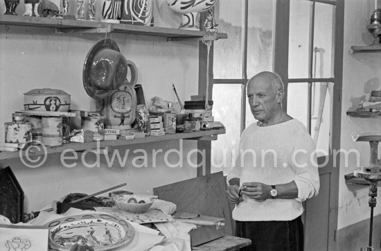Pablo Picasso in front of a board with ceramics. Le Fournas, Vallauris 1953. - Photo by Edward Quinn