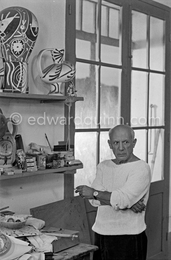 Pablo Picasso in front of a board with ceramics. Le Fournas, Vallauris 1953. - Photo by Edward Quinn