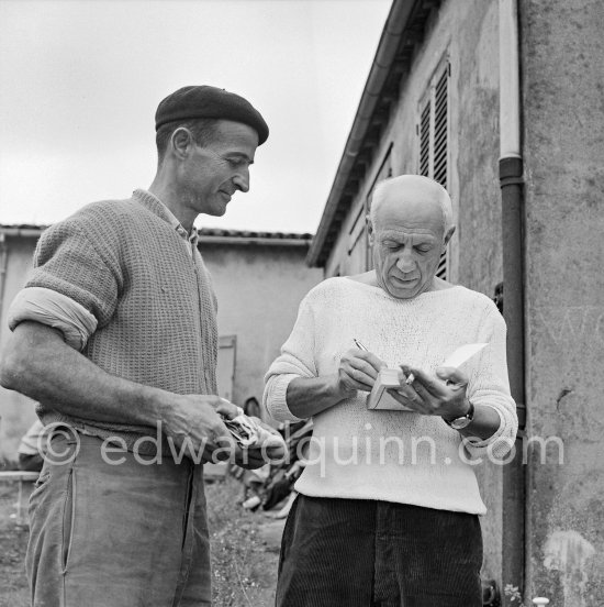 Pablo Picasso signing autograph for a Luciano Emmer Film team member. In front of Le Fournas, Vallauris 1953. - Photo by Edward Quinn