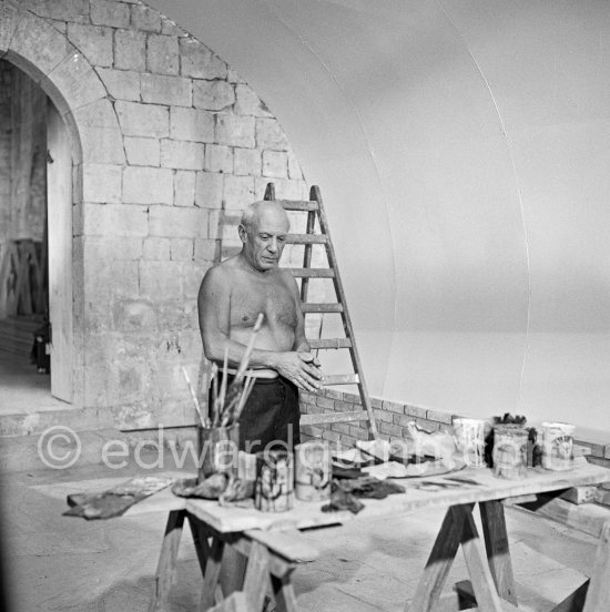 Pablo Picasso working on the "War and Peace study" drawings on the wall of Chapelle de la Paix (or Temple de la Paix) for the documentary film of Luciano Emmer. (The panels of War and Peace of 1952 were away on exhibition). Vallauris 1953. - Photo by Edward Quinn