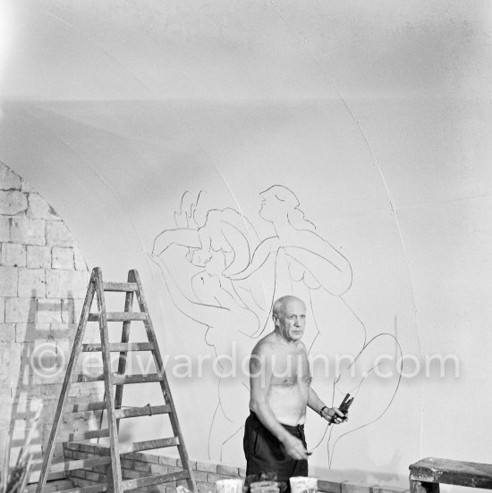 Pablo Picasso working on the "War and Peace study" drawings on the wall of Chapelle de la Paix (or Temple de la Paix) for the documentary film of Luciano Emmer. (The panels of War and Peace of 1952 were away on exhibition). Vallauris 1953. - Photo by Edward Quinn