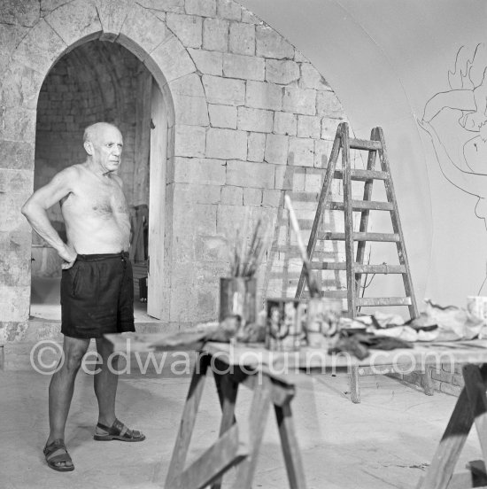 Pablo Picasso working on the "War and Peace study" drawings on the wall of Chapelle de la Paix (or Temple de la Paix) for the documentary film of Luciano Emmer. (The panels of War and Peace of 1952 were away on exhibition). Vallauris 1953. - Photo by Edward Quinn