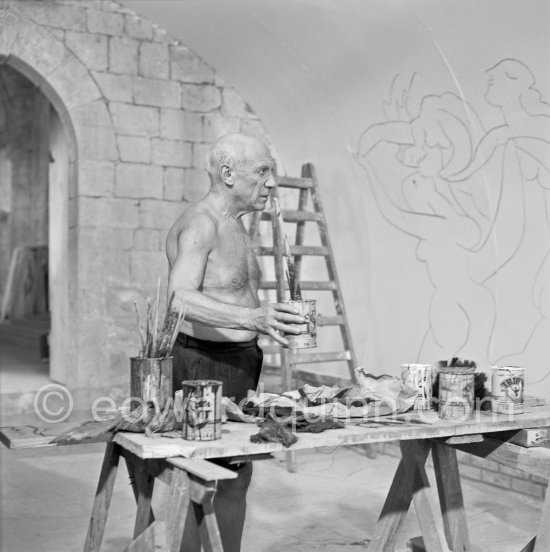 Pablo Picasso working on the "War and Peace study" drawings on the wall of Chapelle de la Paix (or Temple de la Paix) for the documentary film of Luciano Emmer. (The panels of War and Peace of 1952 were away on exhibition). Vallauris 1953. - Photo by Edward Quinn