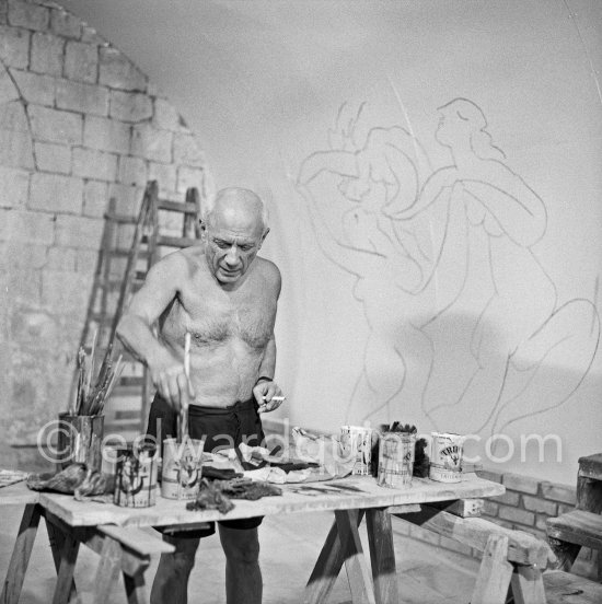 Pablo Picasso working on the "War and Peace study" drawings on the wall of Chapelle de la Paix (or Temple de la Paix) for the documentary film of Luciano Emmer. (The panels of War and Peace of 1952 were away on exhibition). Vallauris 1953. - Photo by Edward Quinn