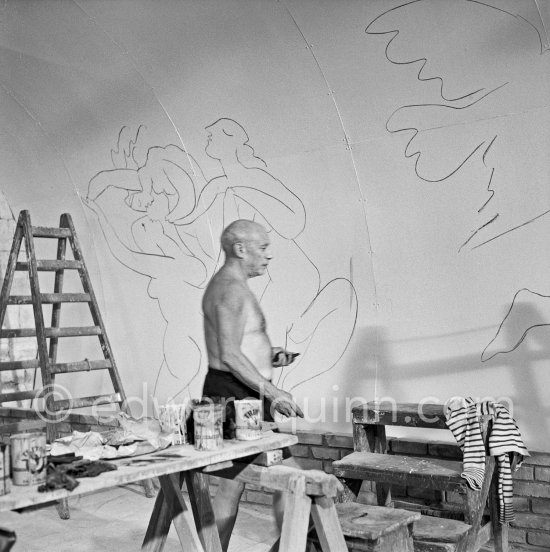 Pablo Picasso working on the "War and Peace study" drawings on the wall of Chapelle de la Paix (or Temple de la Paix) for the documentary film of Luciano Emmer. (The panels of War and Peace of 1952 were away on exhibition). Vallauris 1953. - Photo by Edward Quinn