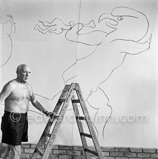 Pablo Picasso working on the "War and Peace study" drawings on the wall of Chapelle de la Paix (or Temple de la Paix) for the documentary film of Luciano Emmer. (The panels of War and Peace of 1952 were away on exhibition). Vallauris 1953. - Photo by Edward Quinn