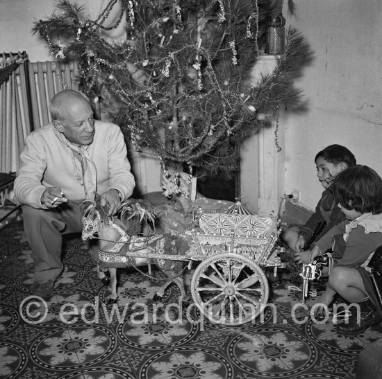 Pablo Picasso with Paloma Picasso and Claude Picasso. The wagon was a gift from reporter Alfredo Quaglino and comes from Sicily. Christmas at La Galloise, Vallauris 1953. - Photo by Edward Quinn