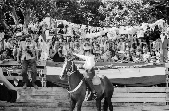 Françoise Gilot led the toreadors into the bull ring and is here seen shaking hands with Pablo Picasso. On the grandstand singer Yolanda on Pablo Picasso\'s right, Hélène Parmelin, Edouard Pignon, far right Paloma Picasso with her nanny. Corrida Vallauris 1954. - Photo by Edward Quinn