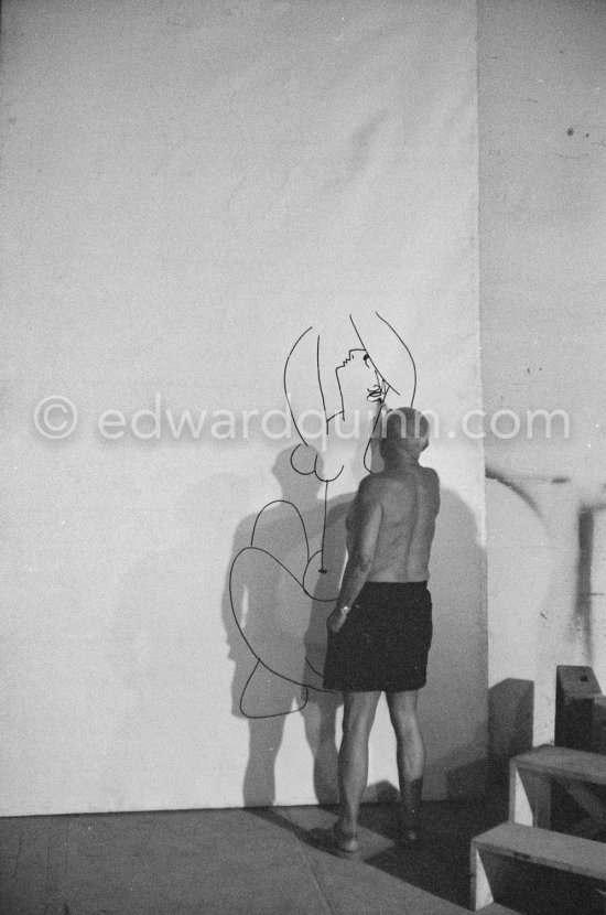 Pablo Picasso working on a bucolic pastoral scene on drawing paper which was to serve as background for the film "Le mystère Picasso". Nice, Studios de la Victorine 1955. - Photo by Edward Quinn