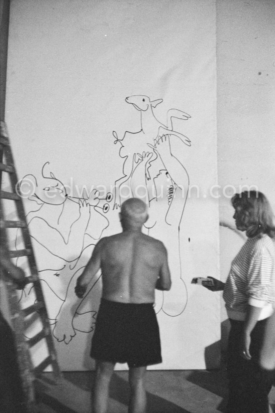 Pablo Picasso working on a bucolic pastoral scene on drawing paper which was to serve as background for the film "Le mystère Picasso". Maya Picasso on the right. Nice, Studios de la Victorine 1955. - Photo by Edward Quinn