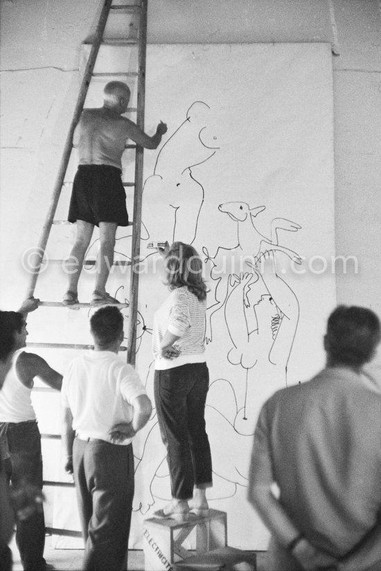 Pablo Picasso working on a bucolic pastoral scene on drawing paper which was to serve as background for the film "Le mystère Picasso". Maya Picasso on the right. Nice, Studios de la Victorine 1955. - Photo by Edward Quinn