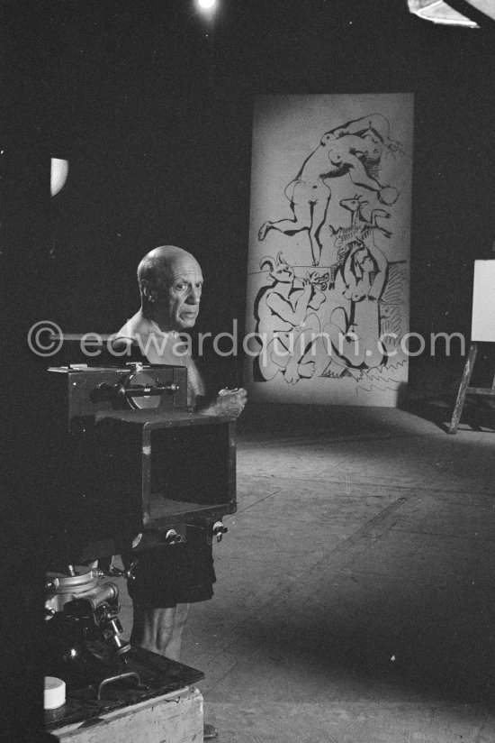 Pablo Picasso working on a bucolic pastoral scene on drawing paper which was to serve as background for the film "Le mystère Picasso". Nice, Studios de la Victorine 1955. - Photo by Edward Quinn