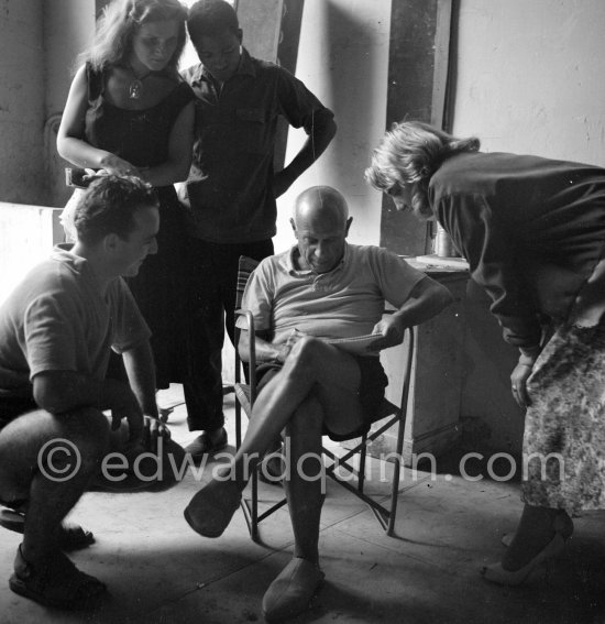 Pablo Picasso drawing during filming of "Le mystère Picasso". With Maya Picasso and visitors. Nice Studios de la Victorine), 1955. - Photo by Edward Quinn