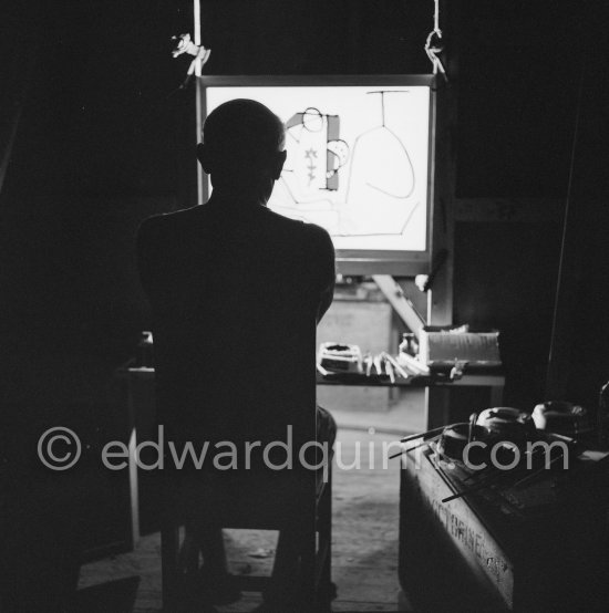 During filming of "Le mystère Picasso". Pablo Picasso working on "Nature morte". Pablo Picasso had a frame constructed on which he could stretch a transluscent piece of paper. He drew on one side, and the camera filmed the drawing being born from the other side. Nice, Studios de la Victorine 1955. - Photo by Edward Quinn