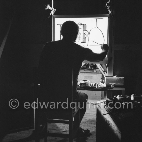 During filming of "Le mystère Picasso". Pablo Picasso working on "Nature morte". Pablo Picasso had a frame constructed on which he could stretch a transluscent piece of paper. He drew on one side, and the camera filmed the drawing being born from the other side. Nice, Studios de la Victorine 1955. - Photo by Edward Quinn
