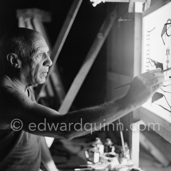 During filming of "Le mystère Picasso". Pablo Picasso working on "Nature morte". Pablo Picasso had a frame constructed on which he could stretch a transluscent piece of paper. He drew on one side, and the camera filmed the drawing being born from the other side. Nice, Studios de la Victorine 1955. - Photo by Edward Quinn