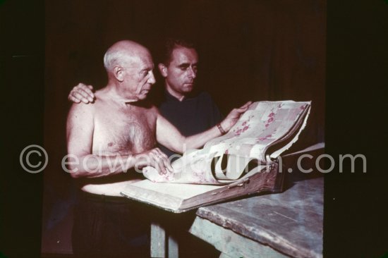 Pablo Picasso and Henri-Georges Clouzot studying a catalog of tapestries. Pablo Picasso used cut-outs for the two paintings "Nature morte sur une commode", 1955 and "Femme nue allongé" or "Grand nu allongé". Nice, Studios de la Victorine, 1955. - Photo by Edward Quinn