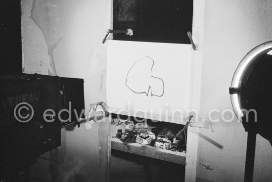 During filming of "Le mystère Picasso". Pablo Picasso working on "Tête de femme" with colored ink. He had a frame constructed on which he could stretch a transluscent piece of paper. He drew on one side, and the camera filmed the drawing being born from the other side. Nice, Studios de la Victorine 1955. - Photo by Edward Quinn