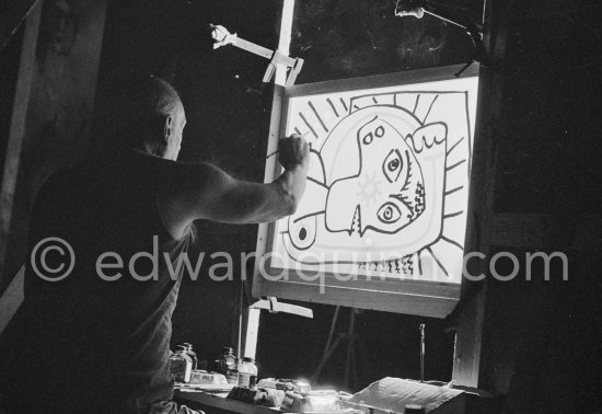 During filming of "Le mystère Picasso". Pablo Picasso working on "Tête de femme" with colored ink. He had a frame constructed on which he could stretch a transluscent piece of paper. He drew on one side, and the camera filmed the drawing being born from the other side. Nice, Studios de la Victorine 1955. - Photo by Edward Quinn