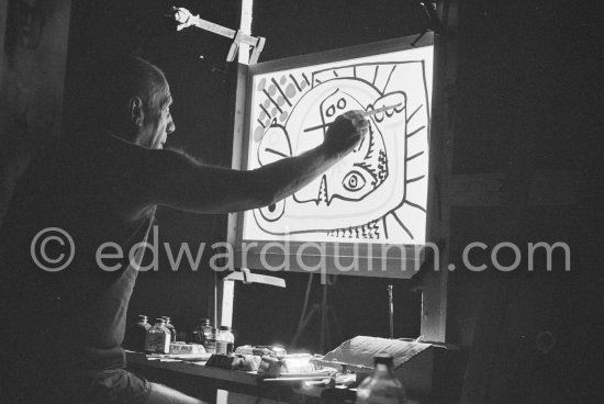 During filming of "Le mystère Picasso". Pablo Picasso working on "Tête de femme" with colored ink. He had a frame constructed on which he could stretch a transluscent piece of paper. He drew on one side, and the camera filmed the drawing being born from the other side. Nice, Studios de la Victorine 1955. - Photo by Edward Quinn