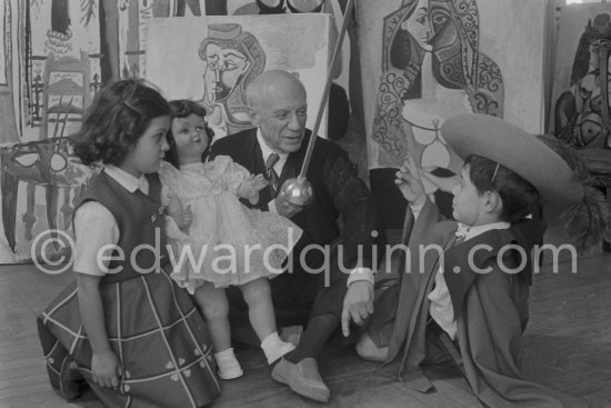 Pablo Picasso with Claude Picasso in "cap et épée" dress, Paloma Picasso with doll. La Californie, Cannes, Christmas 1955. - Photo by Edward Quinn