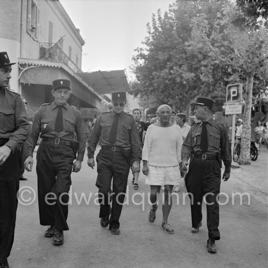 Pablo Picasso with policemen before the corrida put on in his honor. Jacqueline on the left in the background. Vallauris 1955. - Photo by Edward Quinn
