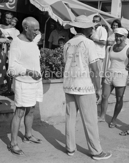 Pablo Picasso and a tourist wearing a shirt with a Pablo Picasso drawing. Local Corrida. In front of restaurant Le Vallauris. Vallauris 1955. - Photo by Edward Quinn