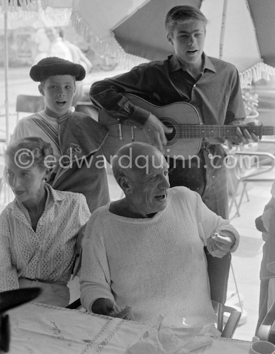 Pablo Picasso and Francine Weisweiller at the lunch given for his friends at restaurant Le Vallauris before the bullfight. Behind them the sons of the writer José Herrera-Petere. Vallauris 1955. - Photo by Edward Quinn