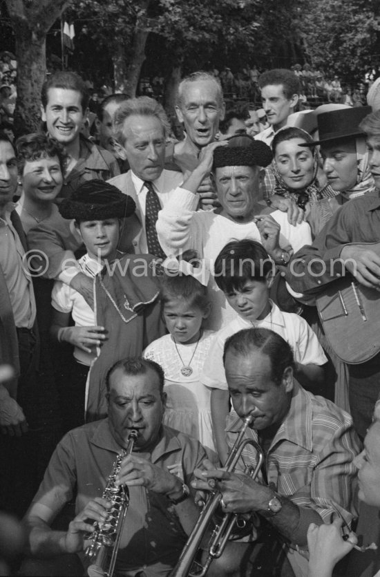 At Pablo Picasso\'s arrival on the village square where the corrida is to be held the band blares out some of his favourite Spanish melodies. Jacques-Henri Lartigue, his wife Florette, photographer, Jean Cocteau, Pablo Picasso, Jacqueline, Maya Picasso, Paloma Picasso and Claude Picasso. Vallauris 1955. - Photo by Edward Quinn