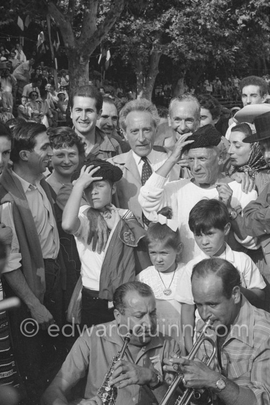 At Pablo Picasso\'s arrival on the village square where the corrida is to be held the band blares out some of his favourite Spanish melodies. From left: Javier Vilató, his wife Germaine Lascaux, Jean Cocteau, Jacques-Henri Lartigue, his wife Florette, photographer (behind Cocteau), Pablo Picasso, Jacqueline, Paloma Picasso and Claude Picasso. Vallauris 1955. - Photo by Edward Quinn