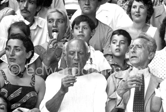 On the grandstand of a bullfight put on in Pablo Picasso's honor. On the left of Pablo Picasso Jacqueline, on the right Jean Cocteau, behind Pablo Picasso his children Paloma Picasso, Maya Picasso and Claude Picasso, and Gérard Sassier. Vallauris 1955. - Photo by Edward Quinn