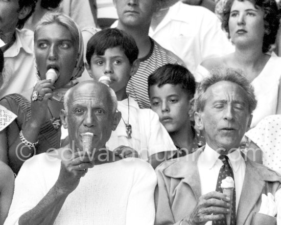 At a local Corrida. During a break, Pablo Picasso and friends refresh themselves with ice cream cornets. Jacqueline, in the background Maya Picasso, Claude Picasso, Paloma Picasso, Jean Cocteau, Francine Weisweiller. Vallauris, 11.8.1955. - Photo by Edward Quinn